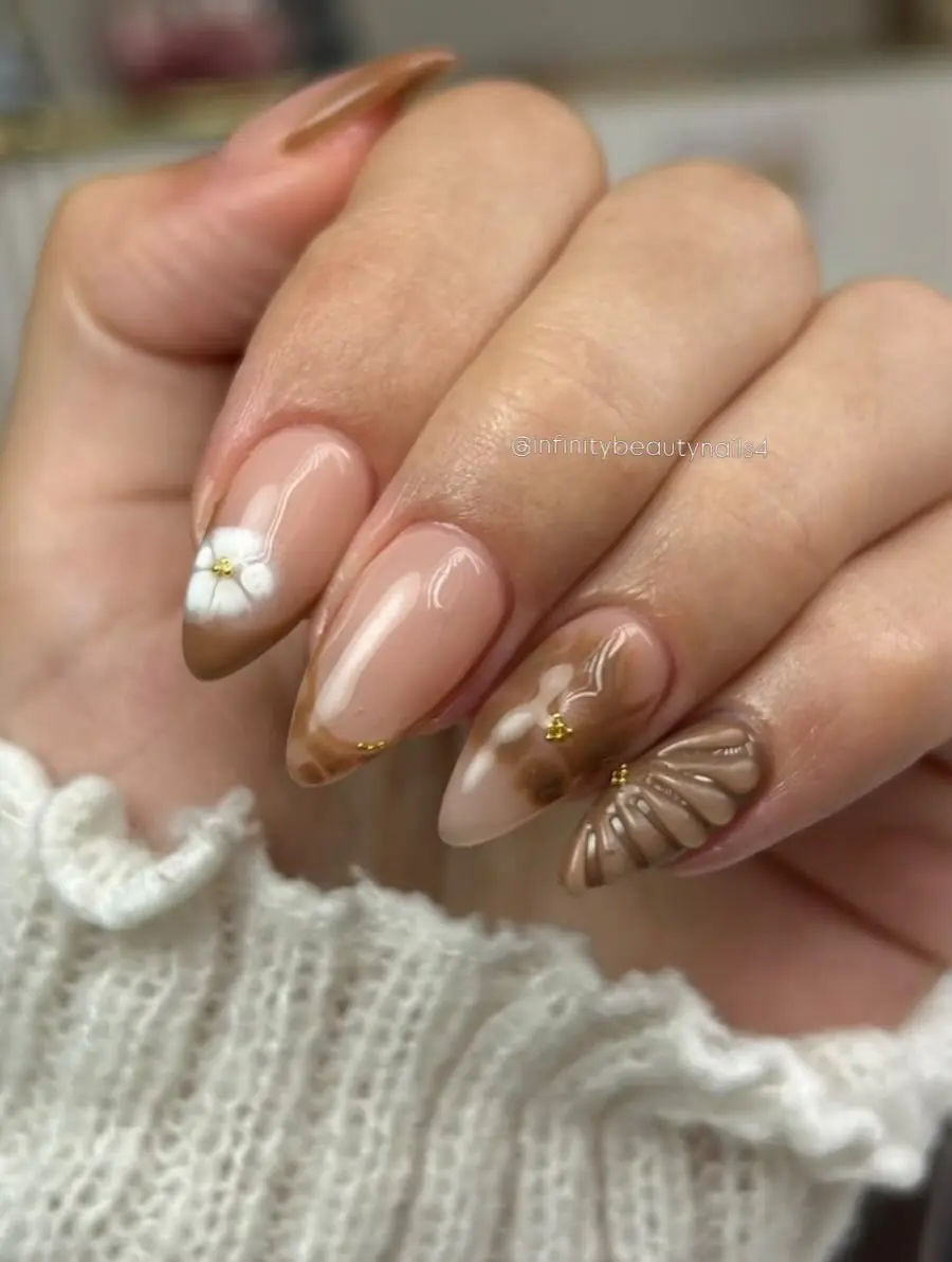 Uñas en tonos café con flores en 3D